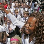 Tracee Reynaud leads a chorus of young children at Santa Maria