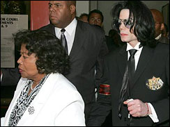 Michael Jackson, center, leaves the Santa Barbara County Courthouse clutching his mother Katherine Jackson's arm and a tissue after a jury acquitted him on all counts in his child molestation trial Monday, June 13, 2005 in Santa Maria, Calif.